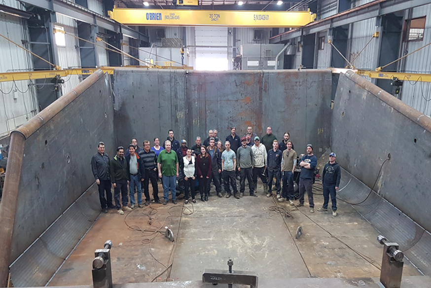 AWC Guelph Team standing in a giant metal box used on dump trucks